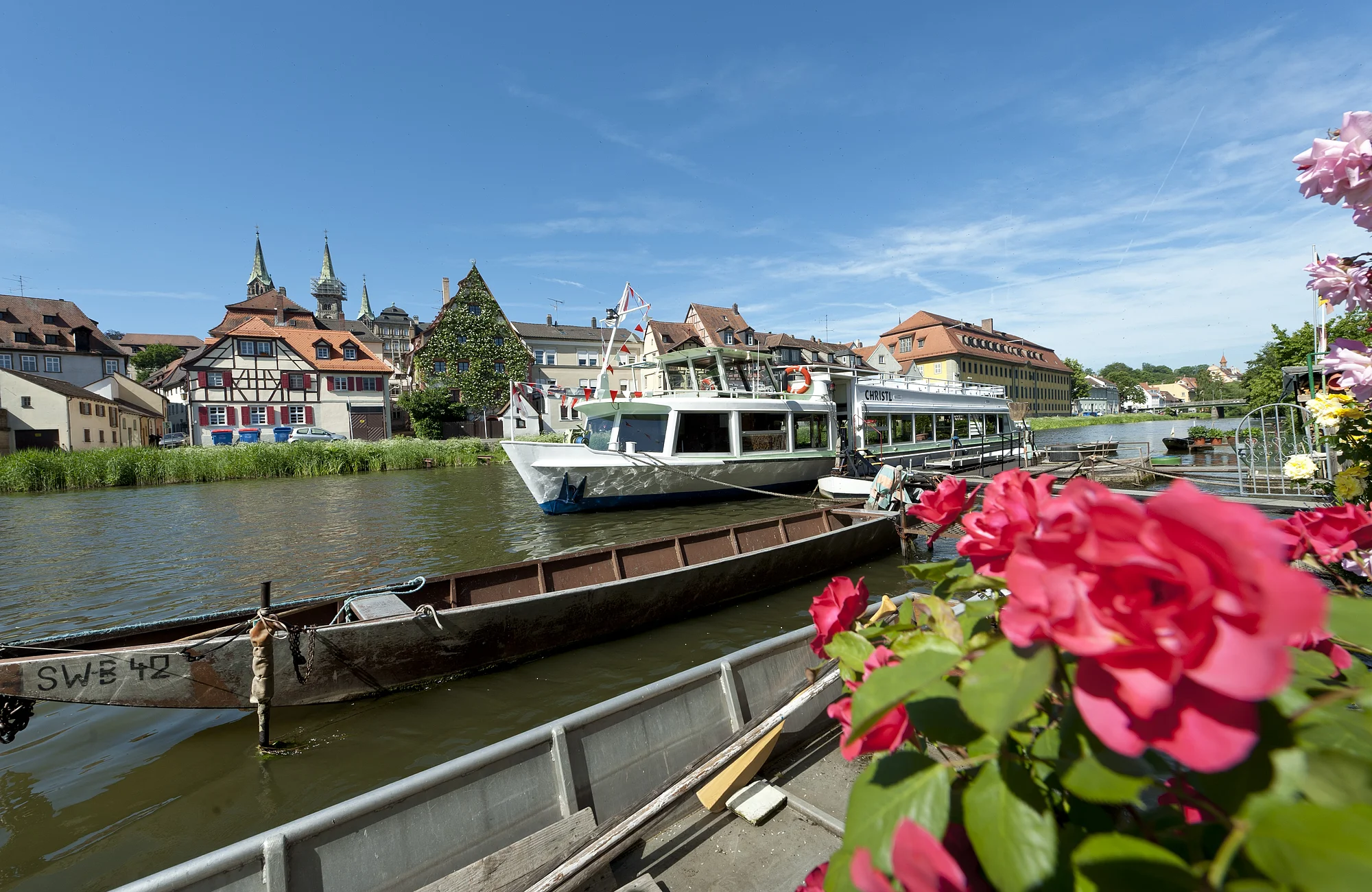 Blick von Klein Venedig auf ein Ausflugsschiff Die ehemalige Fischersiedlung wird liebevoll "Klein Venedig" genannt, Sie besteht aus einer hübsch geschmückten Zeile alter Fachwerkbauten, überwiegend von mittelalterlicher Bausubstanz. Winzige Vorgärten, an denen sich die Anlegestellen für die Kähe befinden, reihen sich am Ufer der Regnitz aneinander und bilden ein romantisches Ensemble. Mit dem Ausflugsschiff fährt man heute direkt an dieser einmaligen Häuserzeile vorbei.