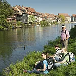 Wanderer machen Rast auf einer Wiese mit Blick auf Klein Venedig.
