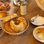 Ein Frühstückstisch mit Bamberger Hörnla, ein typisches Bamberger Gebäck wie ein Croissant, und Kaffee