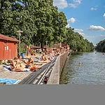 Ein Steg aus Holzbrettern entlang der Regnitz laden im Sommer an der Hainbadestelle zum Sonnenbaden ein.