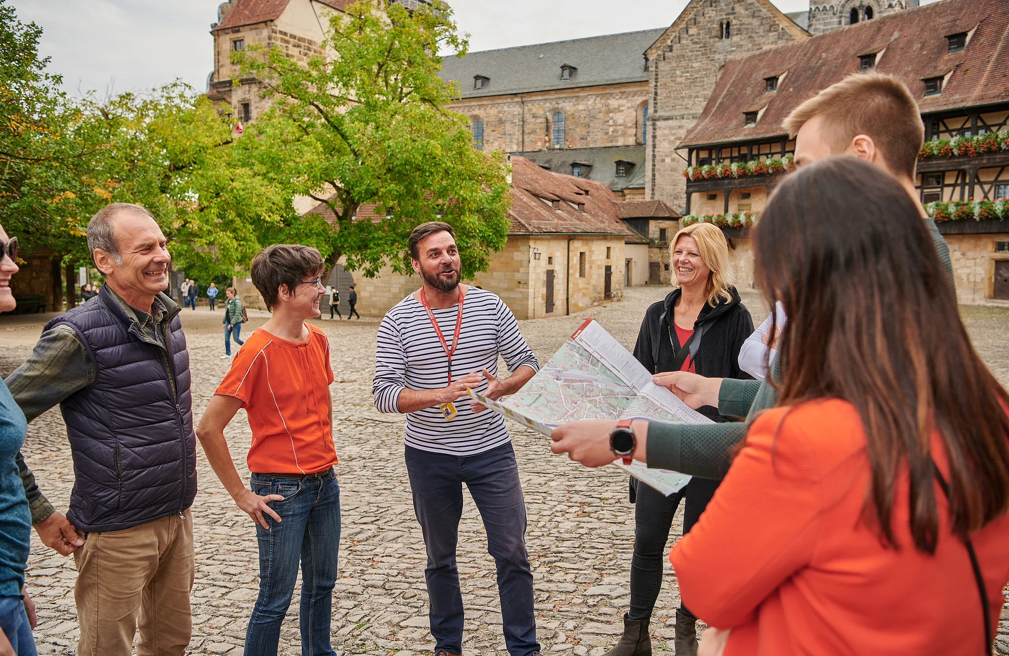 Eine Stadtführungsgruppe  steht in der Alten Hofhaltung. Im hinergrund sieht man den Dom.